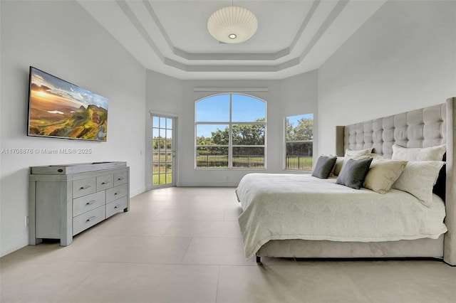 bedroom featuring a raised ceiling and a high ceiling