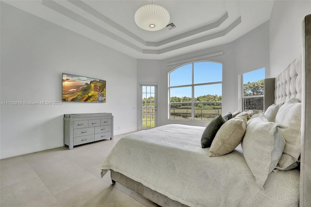 bedroom featuring a towering ceiling and a raised ceiling