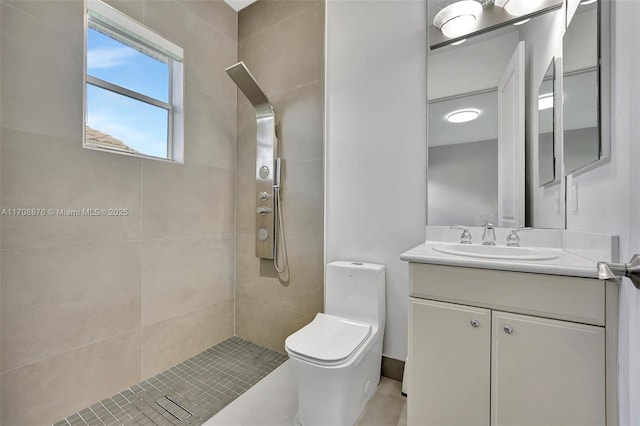 bathroom with vanity, a tile shower, and toilet