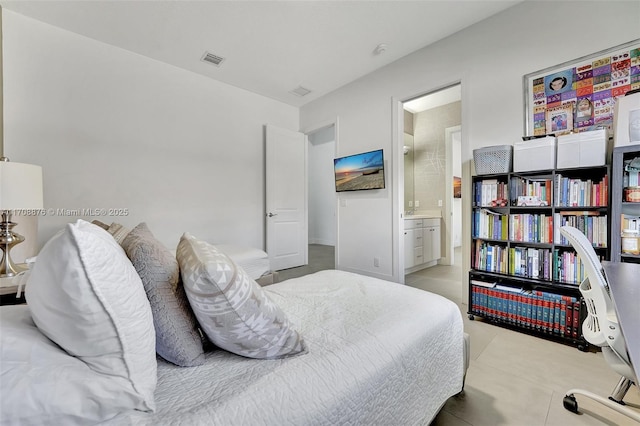 bedroom featuring light tile patterned floors and ensuite bath