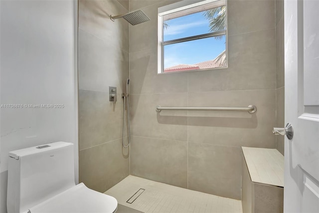 bathroom with toilet and a tile shower