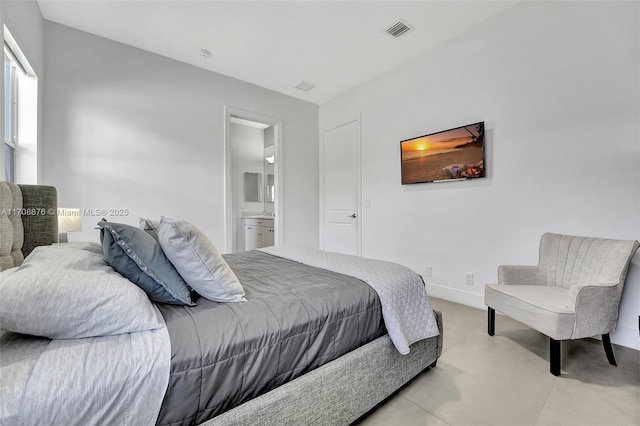 bedroom featuring concrete flooring, connected bathroom, visible vents, and baseboards