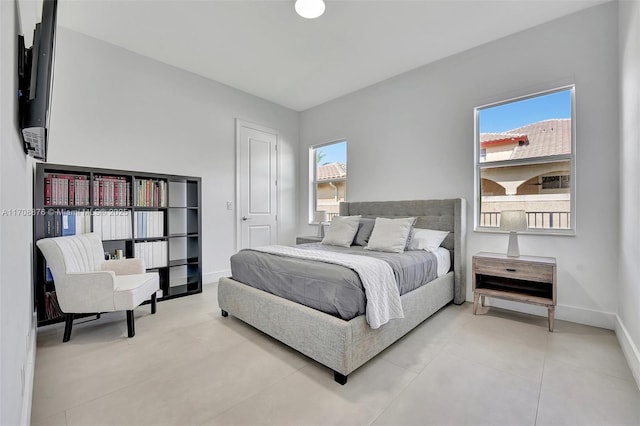 bedroom with light tile patterned floors and baseboards