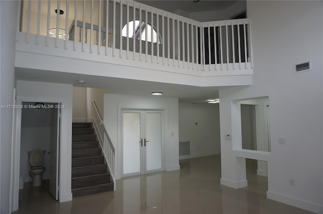 stairway with a healthy amount of sunlight and a towering ceiling