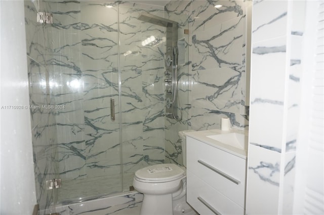 bathroom with vanity, toilet, a shower with door, and tile walls