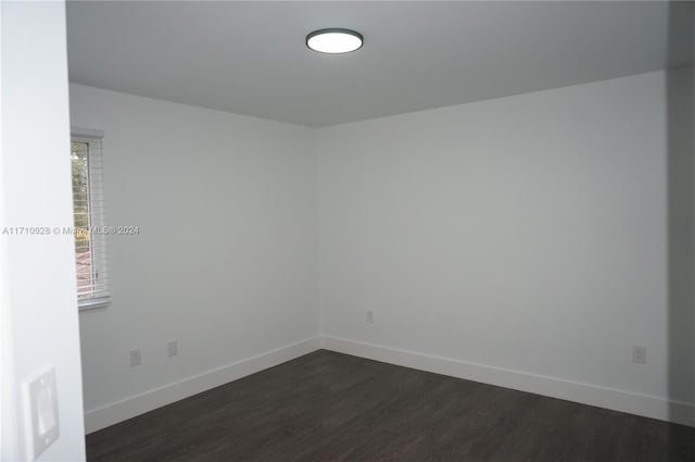 empty room with dark hardwood / wood-style flooring