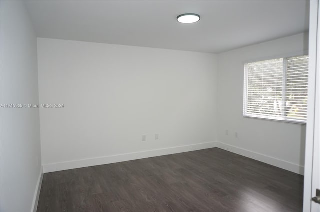 spare room with dark hardwood / wood-style flooring