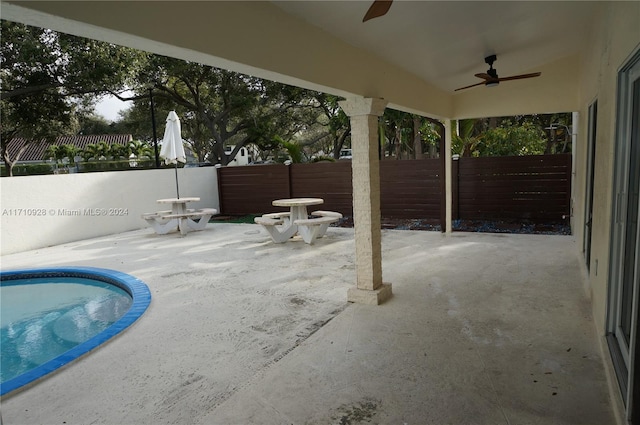 view of patio with ceiling fan and a fenced in pool