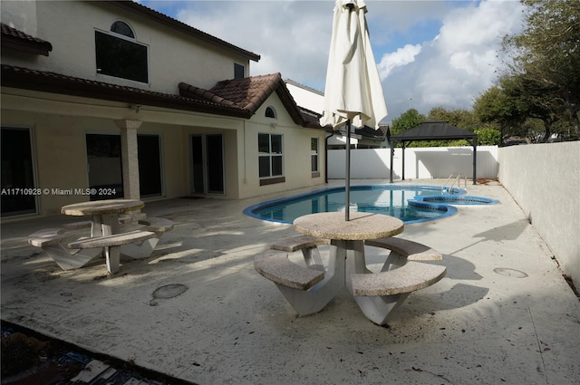 view of pool with a gazebo, a patio area, and an in ground hot tub