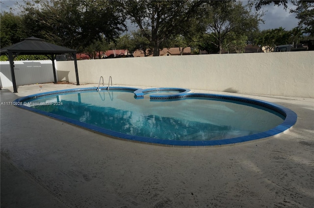 view of swimming pool with a gazebo, a patio area, and an in ground hot tub