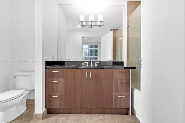 bathroom featuring vanity, an inviting chandelier, toilet, and a shower with shower door