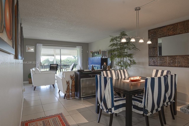 tiled dining room featuring a textured ceiling