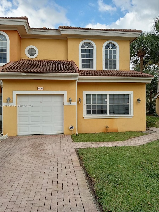 mediterranean / spanish-style house with a garage and a front yard