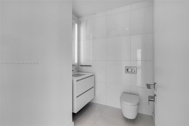 bathroom with tile walls, toilet, tile patterned floors, and vanity