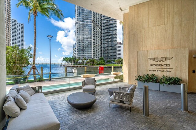 view of patio featuring a water view, outdoor lounge area, and an in ground hot tub