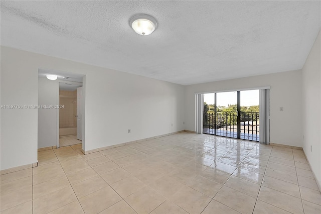 tiled spare room with a textured ceiling