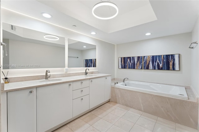 bathroom with tile patterned floors, vanity, and a relaxing tiled tub