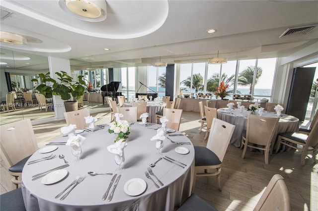 dining space featuring hardwood / wood-style floors and a water view