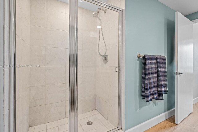 bathroom featuring wood-type flooring and an enclosed shower