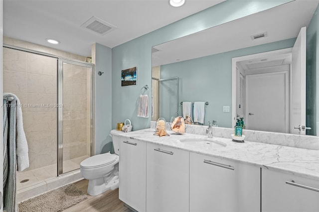 bathroom with wood-type flooring, vanity, toilet, and an enclosed shower