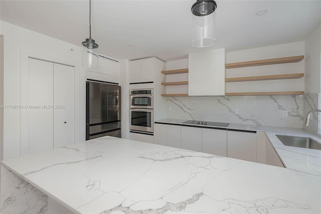 kitchen featuring pendant lighting, backsplash, sink, appliances with stainless steel finishes, and white cabinetry