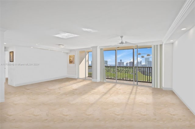 spare room featuring ceiling fan, floor to ceiling windows, and ornamental molding