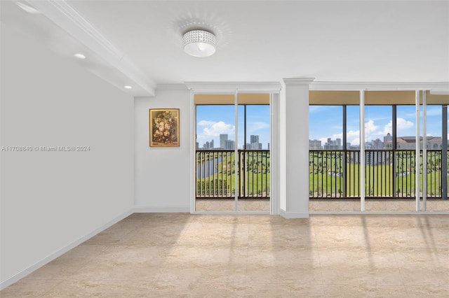 empty room featuring ornamental molding, floor to ceiling windows, and a healthy amount of sunlight