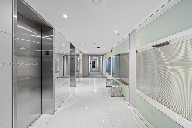 hall featuring light tile patterned flooring and elevator