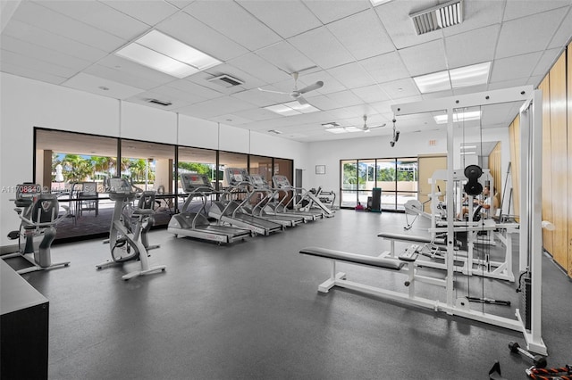 workout area with a paneled ceiling and ceiling fan