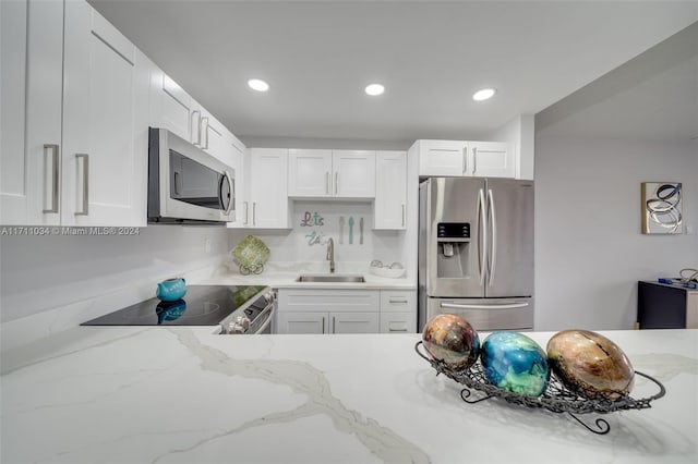 kitchen featuring light stone countertops, sink, white cabinets, and appliances with stainless steel finishes