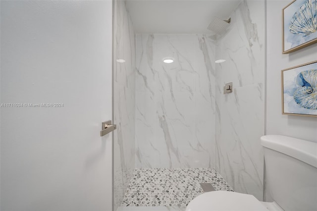 bathroom with toilet and tiled shower