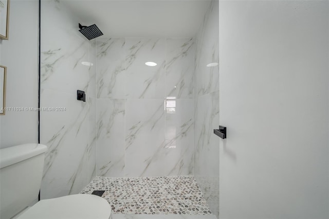 bathroom featuring toilet and tiled shower