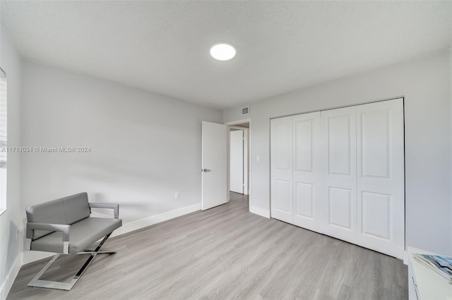 sitting room with a textured ceiling and light wood-type flooring