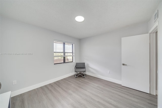 interior space with a textured ceiling and light wood-type flooring