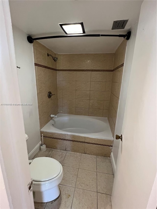 bathroom featuring tile patterned floors, tiled shower / bath combo, and toilet