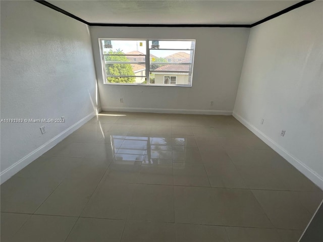 empty room featuring light tile patterned floors and ornamental molding