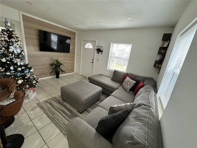 living room featuring light tile patterned floors and wooden walls