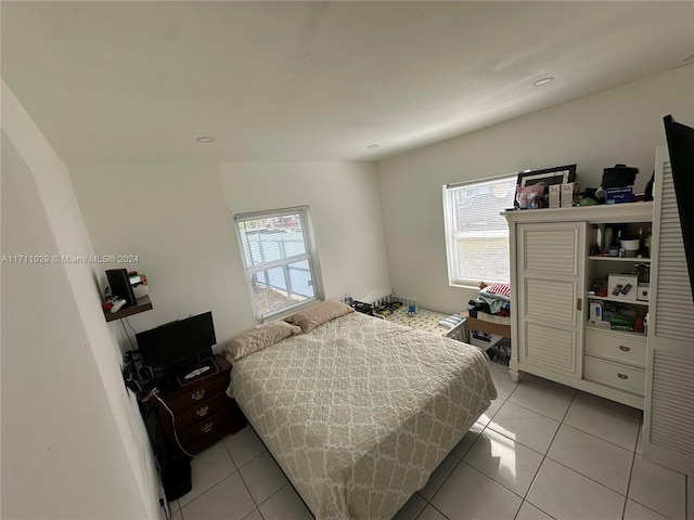 tiled bedroom with multiple windows and vaulted ceiling