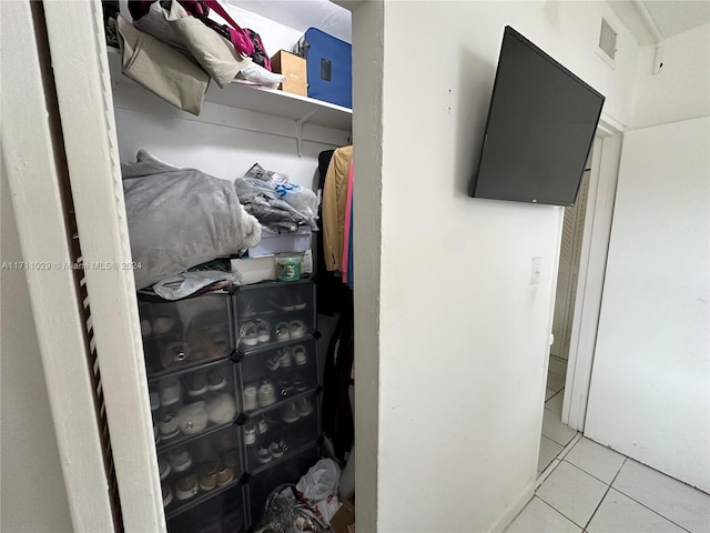 walk in closet with light tile patterned floors