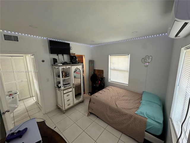 bedroom with light tile patterned floors and a wall unit AC