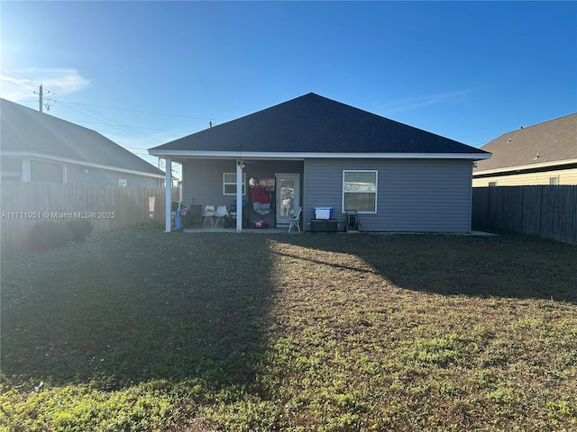 rear view of house with a patio area and a yard