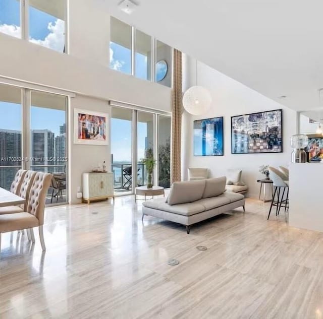 living room featuring a healthy amount of sunlight and a towering ceiling