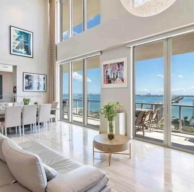 living room featuring a high ceiling and a water view