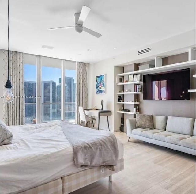 bedroom featuring ceiling fan, light hardwood / wood-style floors, floor to ceiling windows, and access to outside