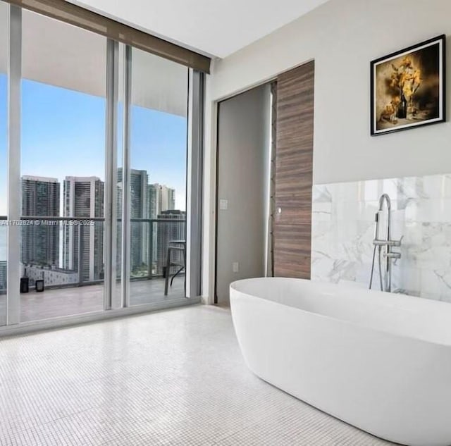 bathroom featuring expansive windows and a tub to relax in