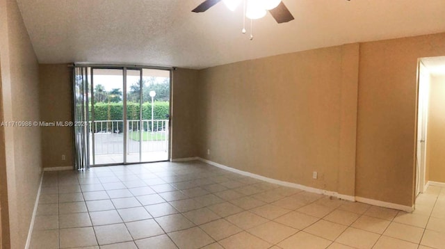 tiled spare room with ceiling fan, a textured ceiling, and vaulted ceiling