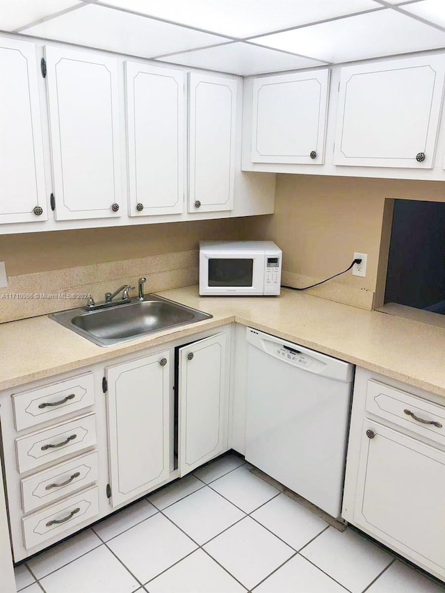 kitchen with light tile patterned floors, white appliances, white cabinetry, and sink