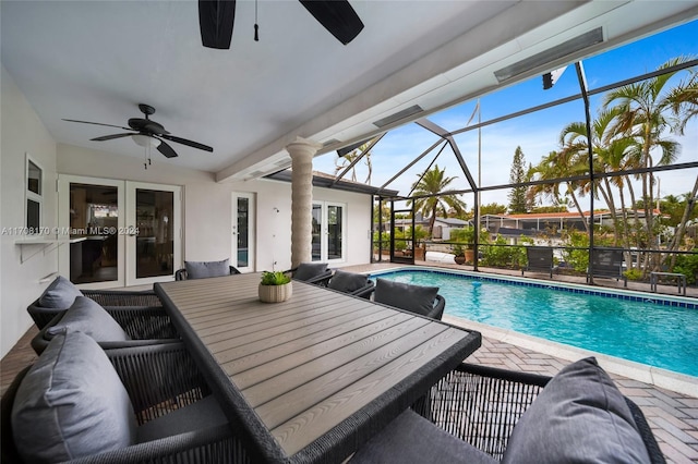 view of swimming pool with french doors, a patio area, ceiling fan, and a lanai