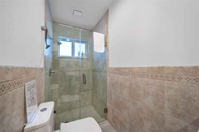 bathroom with walk in shower, tile walls, and toilet