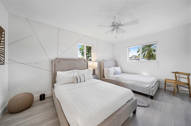 bedroom with light hardwood / wood-style floors, multiple windows, and ceiling fan